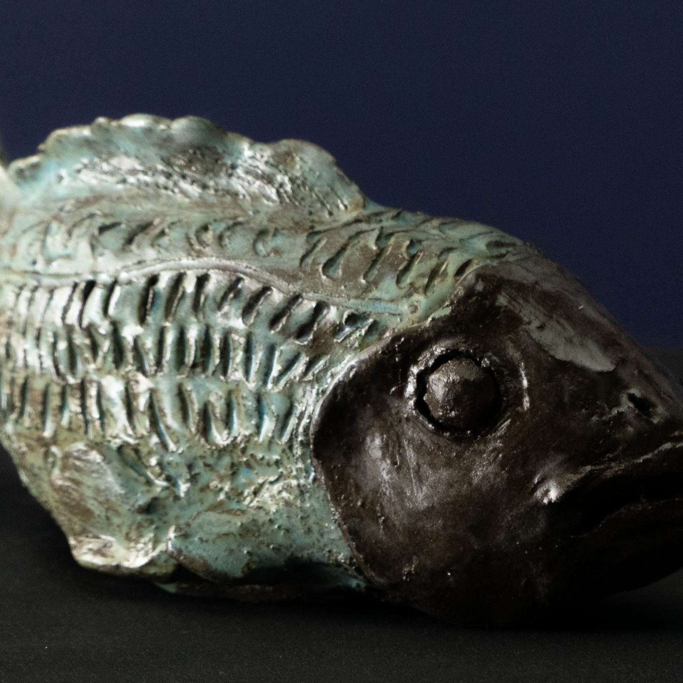 Keramik-Skulptur „Dunkelzone“ von Jutta Eger, schwarzer Ton, stilisierte Fischform mit kompakter Volumenwirkung, Vorderansicht rechts.