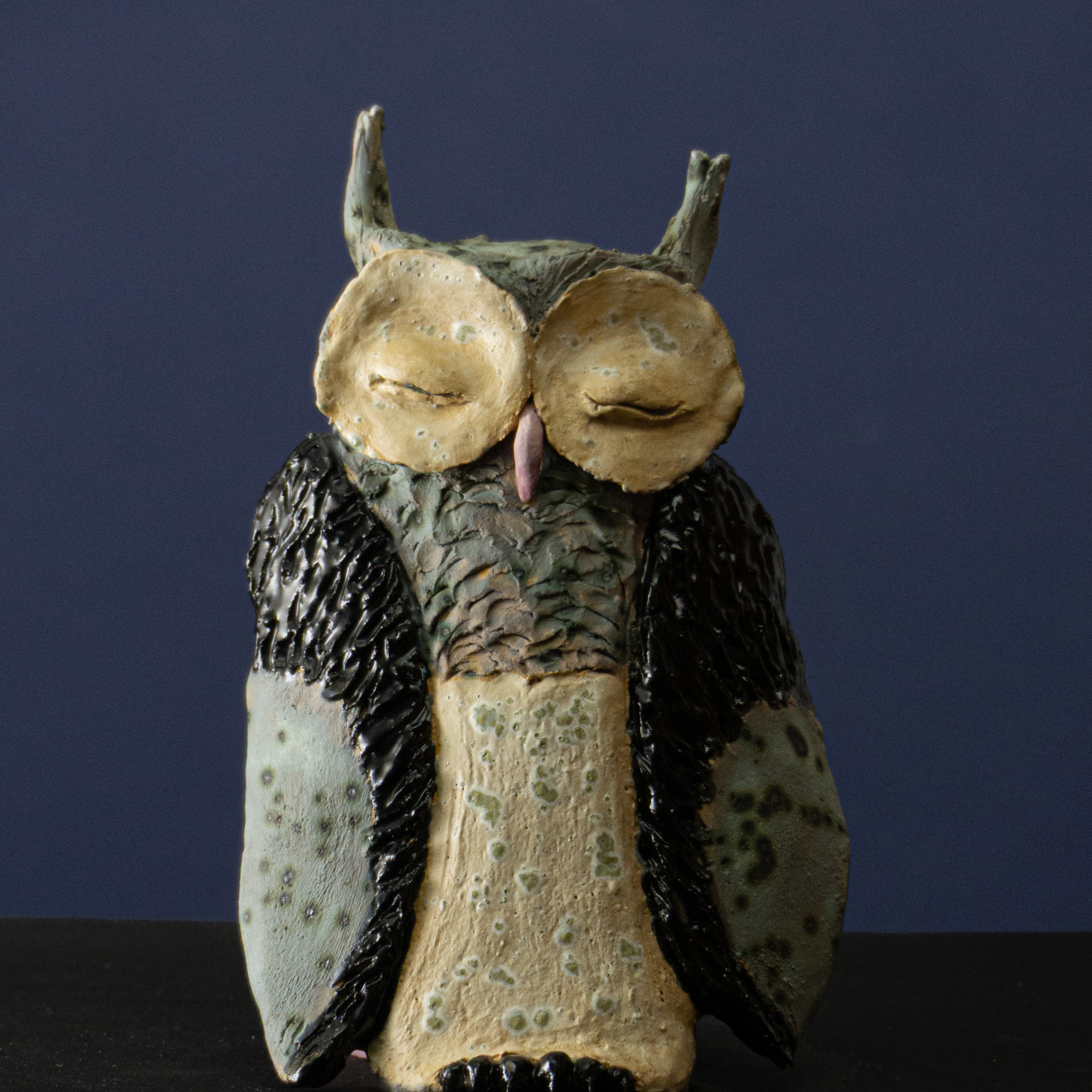 Keramik-Skulptur „Eule“ von Jutta Eger, weißer Ton mit glasierter Oberfläche, flache Wandarbeit mit reliefartiger, dennoch deutlich dreidimensionaler Ausformung, Vorderansicht.