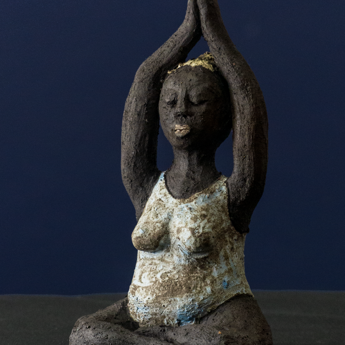 Keramik-Skulptur „Im Retreat“ von Jutta Eger, schwarzer Ton mit Engobe, figurative reduzierte Form mit Yogabezug in zurückgezogener Haltung, Vorderansicht links.