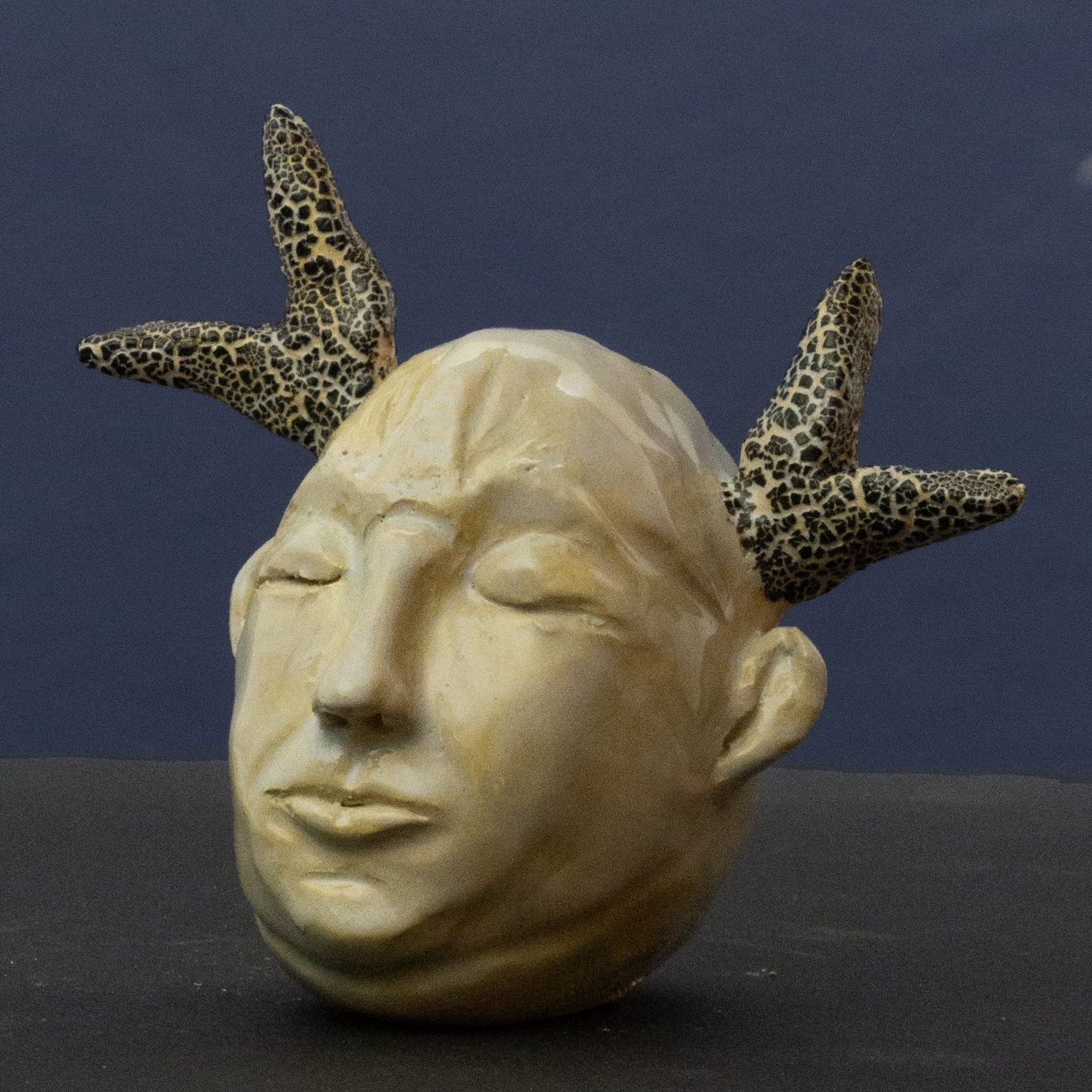 Abstrakte Keramik-Skulptur „Instinkt“ von Jutta Eger, naturfarbener Ton in warmen Beigetönen, kompakte organische Form mit spannungsvoller Linienführung, Vorderansicht links.