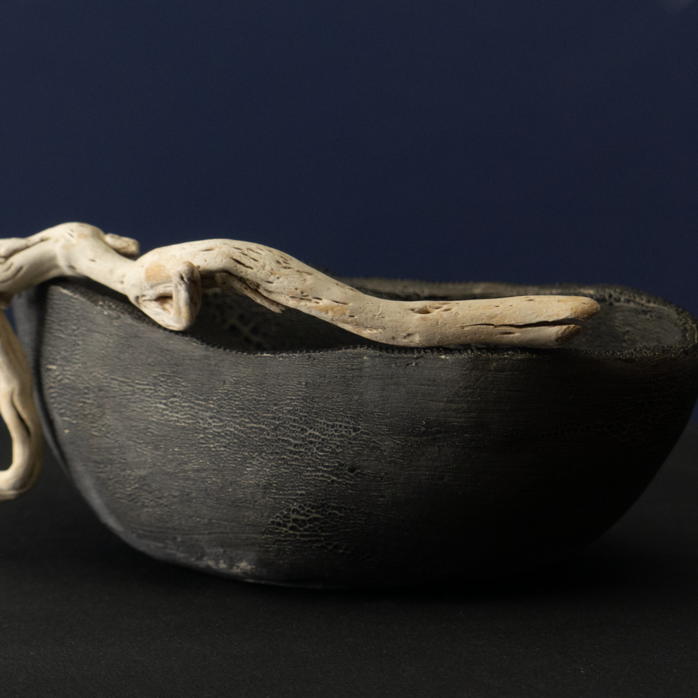 Keramik-Skulptur „Ruhender Akt“ von Jutta Eger, schwarzer Ton mit matter Glasur, liegende figurative Form mit ruhiger Körperhaltung, Vorderansicht.