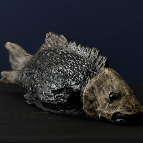 Keramik-Skulptur „Stiller Grund“ von Jutta Eger, schwarzer Ton, stilisierte Fischform mit ruhiger Linienführung, Vorderansicht rechts.