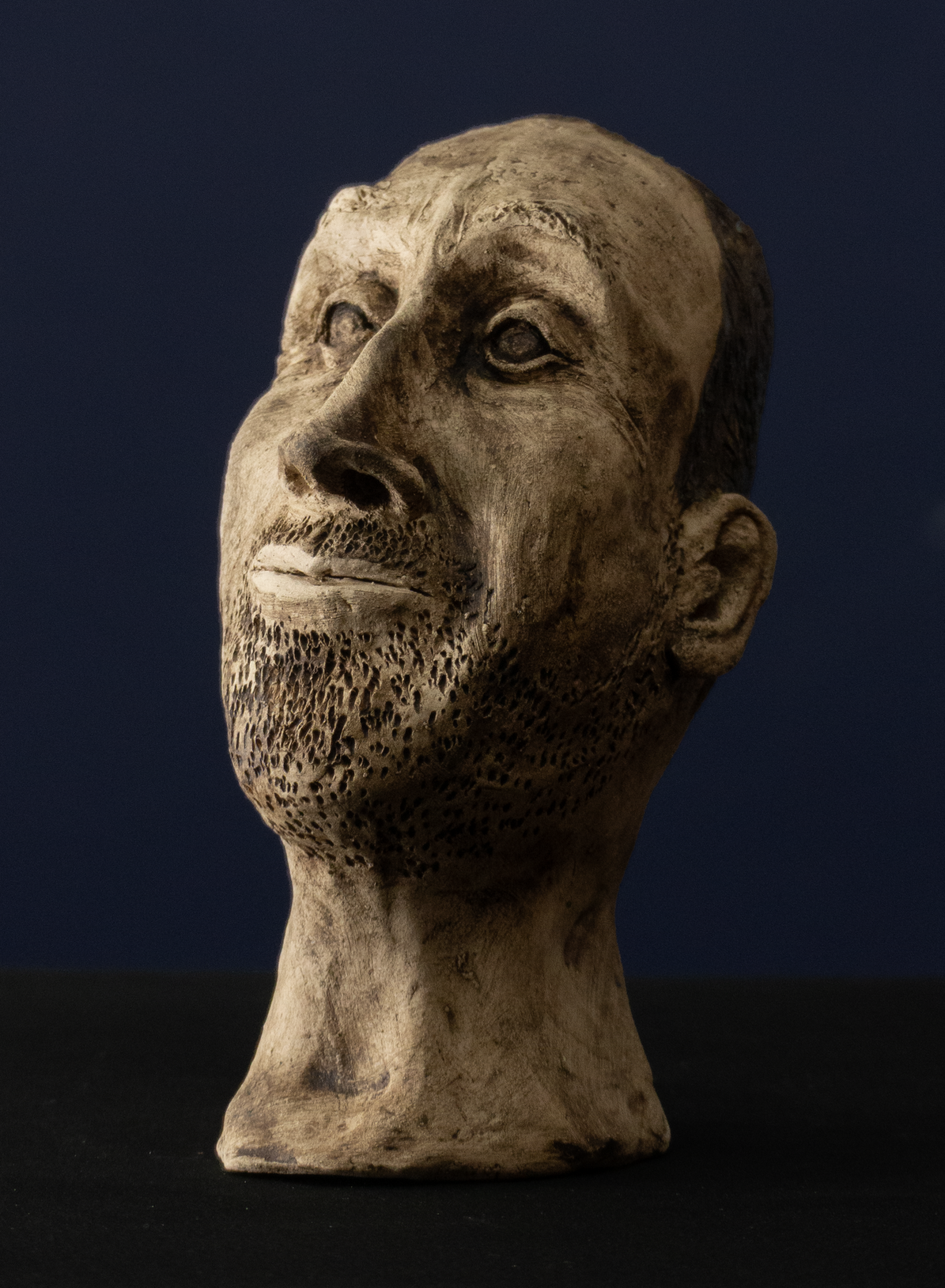 Keramik-Skulptur „Der Denkende“ von Jutta Eger, Engobe-Oberfläche, figurative Form in nachdenklicher Haltung mit betonter Kopfpartie, Vorderansicht links.