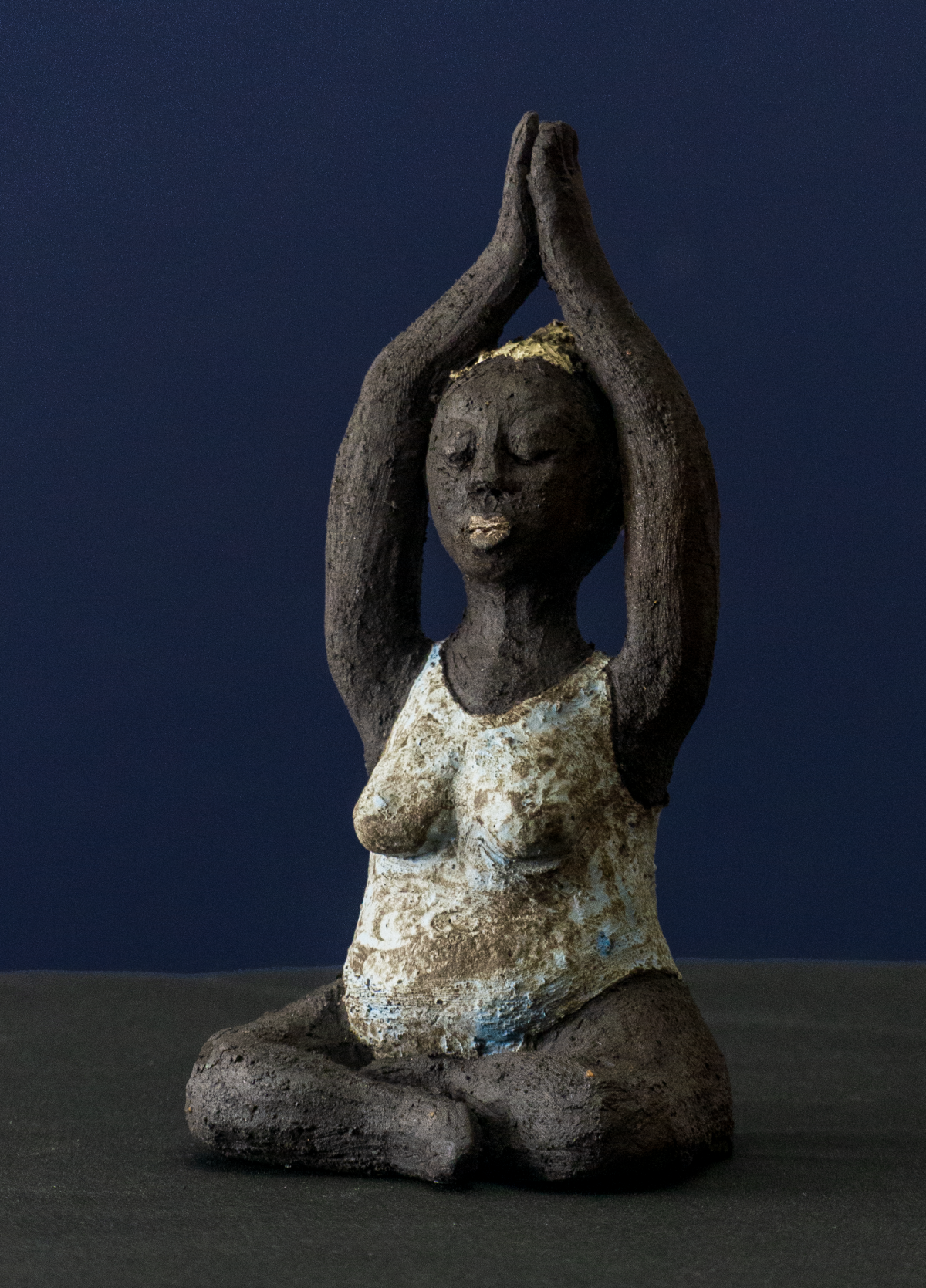 Keramik-Skulptur „Im Retreat“ von Jutta Eger, schwarzer Ton mit Engobe, figurative reduzierte Form mit Yogabezug in zurückgezogener Haltung, Vorderansicht links.