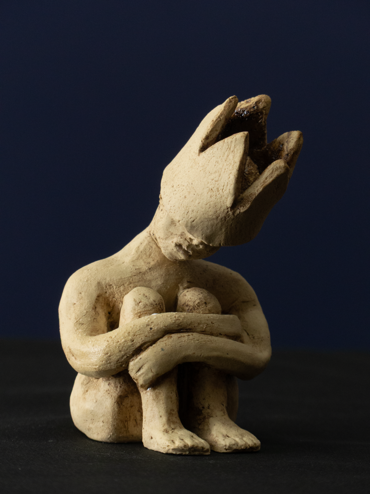 Keramik-Skulptur „Im Rückzug“ von Jutta Eger, weißer Ton mit Engobe, figurative reduzierte Form in zurückgezogener Haltung, Vorderansicht rechts