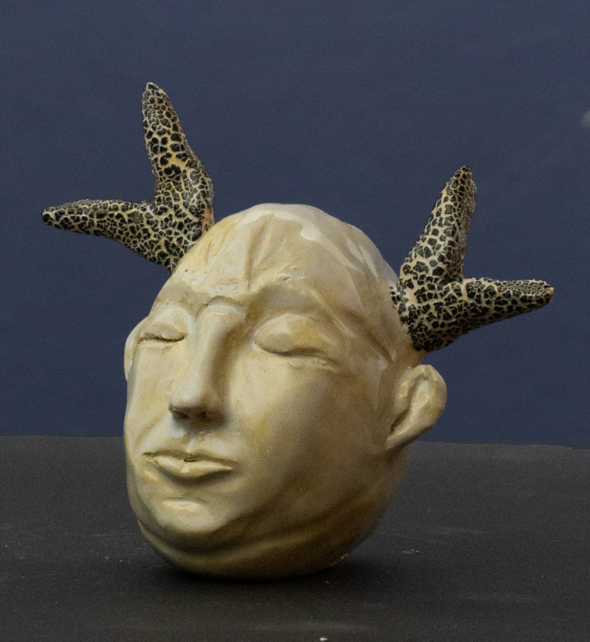 Abstrakte Keramik-Skulptur „Instinkt“ von Jutta Eger, naturfarbener Ton in warmen Beigetönen, kompakte organische Form mit spannungsvoller Linienführung, Vorderansicht links.