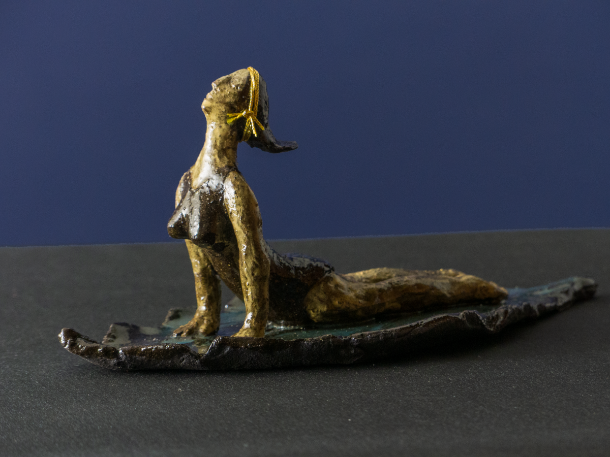 Keramik-Skulptur „Sphinx Yoga“ von Jutta Eger, schwarzer Ton mit glasierter Oberfläche, figurative Form in liegender Haltung mit Bezug zur Yoga-Sphinx-Position, Vorderansicht links.