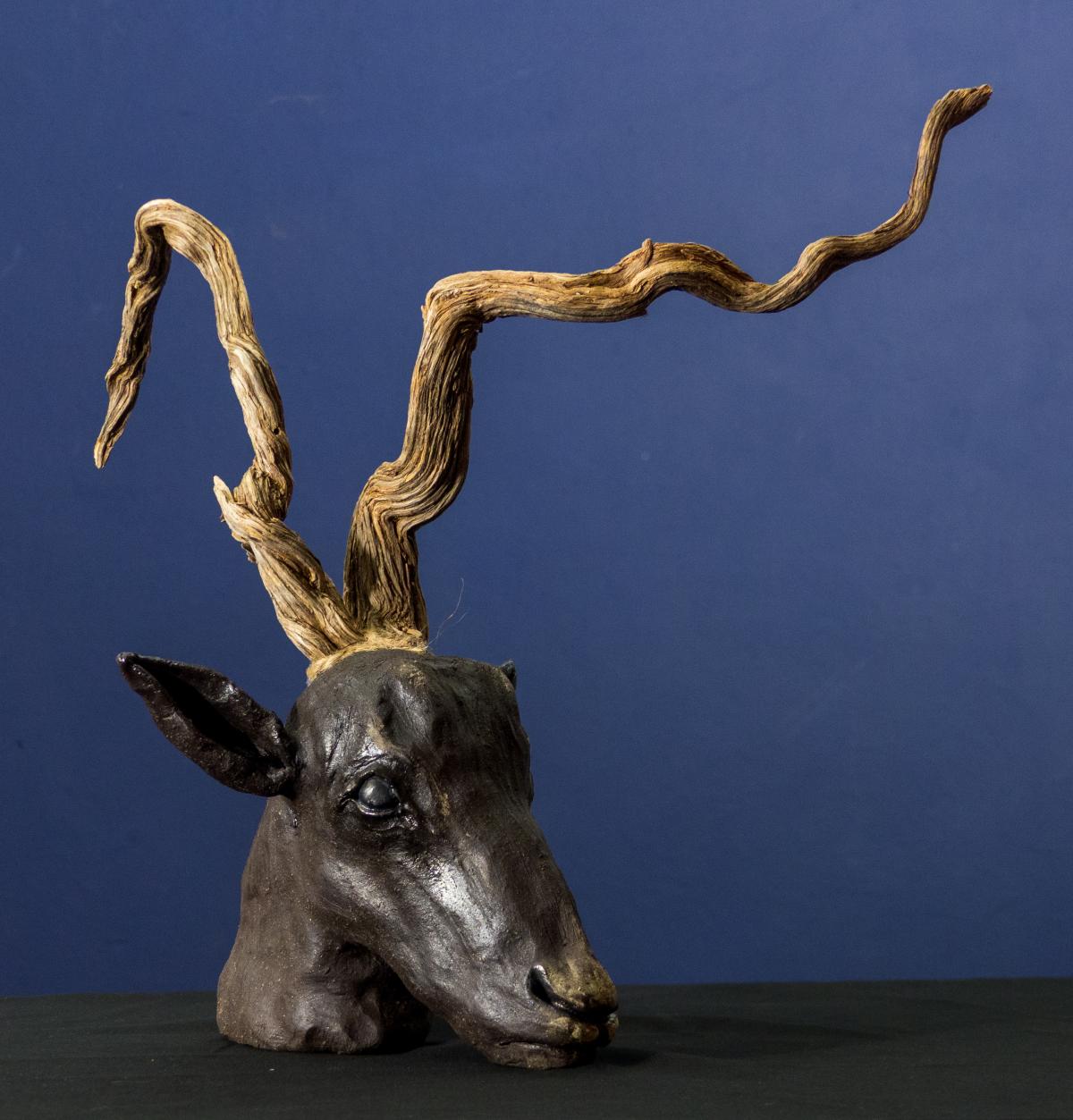 Skulptur aus schwarzem Ton  Weltenast ist eine aus schwarzem Ton gefertigte Skulptur, die die Grenze zwischen Tier, Baum und Landschaft aufhebt. Der Hirschkopf verschmilzt mit einem organisch gewachsenen Geweih, das an verwitterte Äste erinnert und Assoziationen zu Kraft, Zeit und Natur hervorruft. Die reduzierte Form lenkt den Blick auf die symbolische Aussage: Wachstum, Vergänglichkeit und die tiefe Verbindung allen Lebens.  Die dunkle Oberfläche des schwarzen Tons verleiht der Skulptur eine archaische Au
